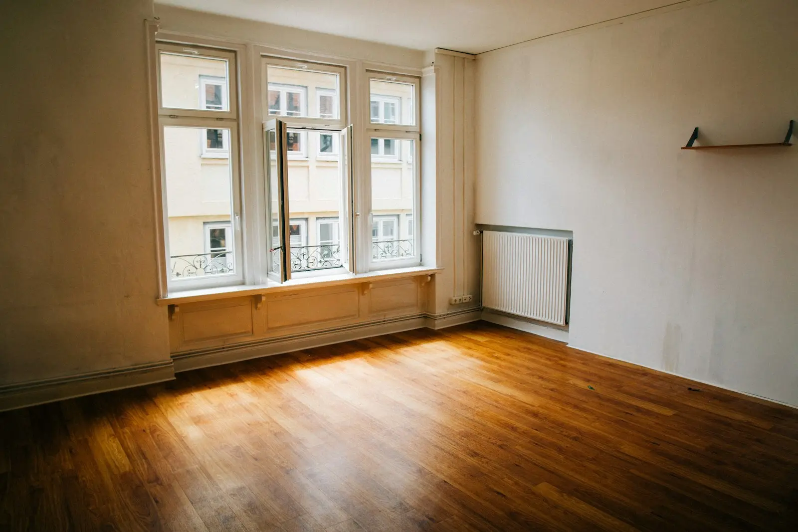 Leerer Raum mit Holzboden und großen Fenstern